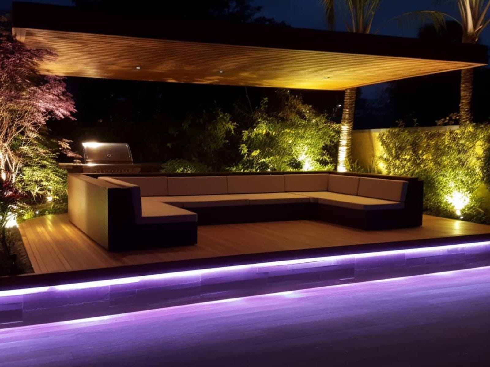 An LED strip light illuminating the perimeter of a backyard deck