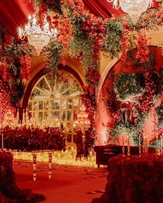 A magnificent indoor lighting setup comprising exotic flowers, crystal chandeliers and candlelights