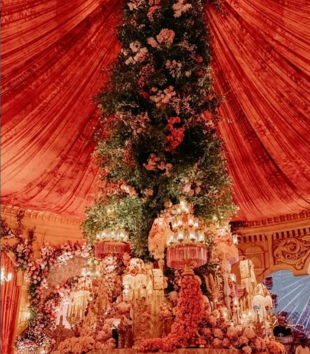A massive tower-shaped floral arrangement comprising candlelights and exotic flowers
